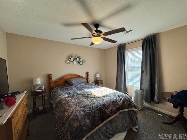 bedroom featuring radiator, ceiling fan, a textured ceiling, and dark colored carpet