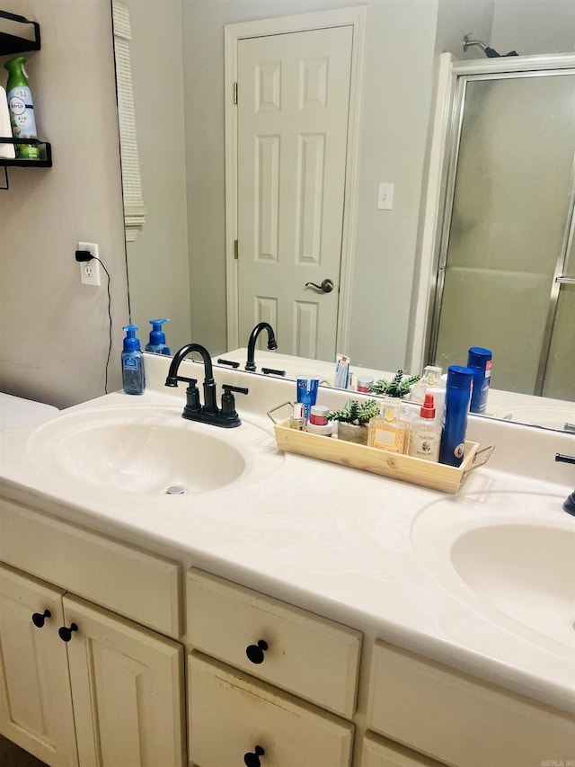 bathroom with vanity and a shower with shower door