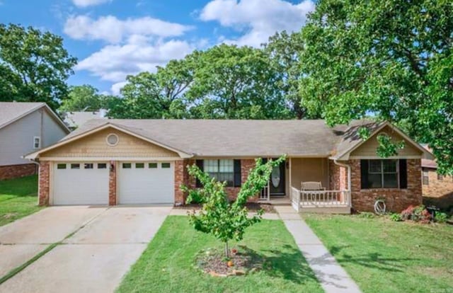 ranch-style home featuring covered porch, a garage, and a front lawn