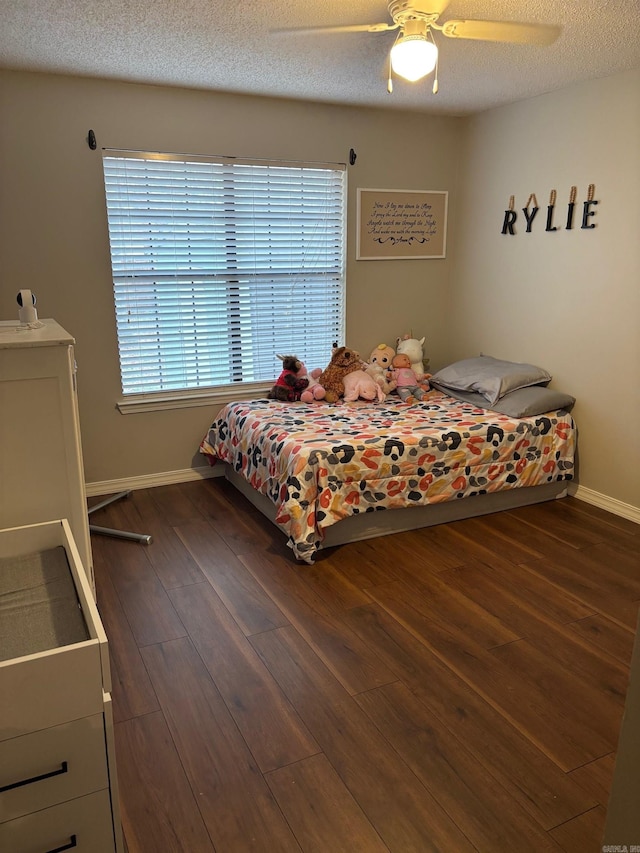 bedroom featuring a textured ceiling, ceiling fan, and dark wood-type flooring