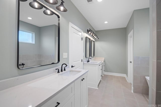 bathroom featuring tile patterned flooring, vanity, and a bathing tub