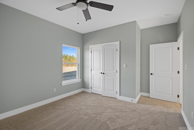 unfurnished bedroom featuring ceiling fan, a closet, and light carpet