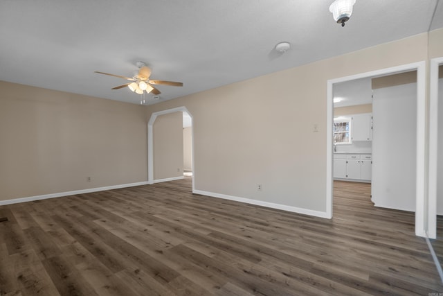 empty room featuring ceiling fan and dark hardwood / wood-style flooring