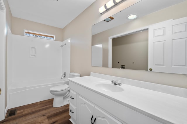 full bathroom with hardwood / wood-style flooring, vanity, toilet, and tub / shower combination