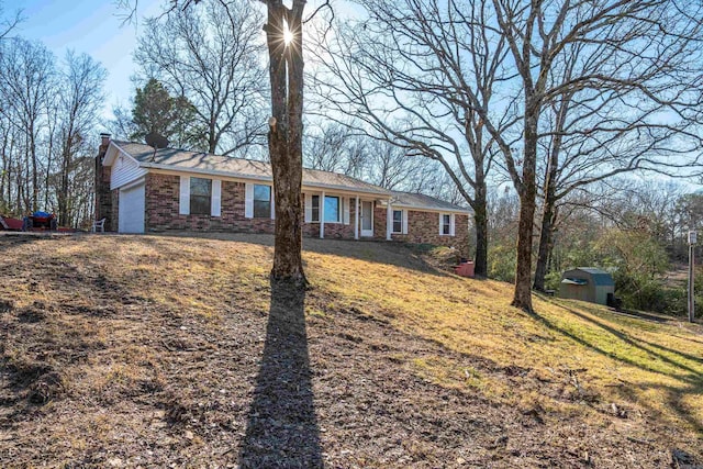 ranch-style house with a shed and a front yard