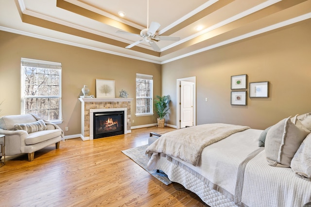 bedroom featuring multiple windows, a raised ceiling, ceiling fan, and ornamental molding