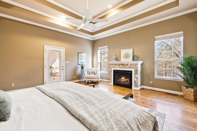 bedroom featuring a raised ceiling, ceiling fan, crown molding, and light hardwood / wood-style floors