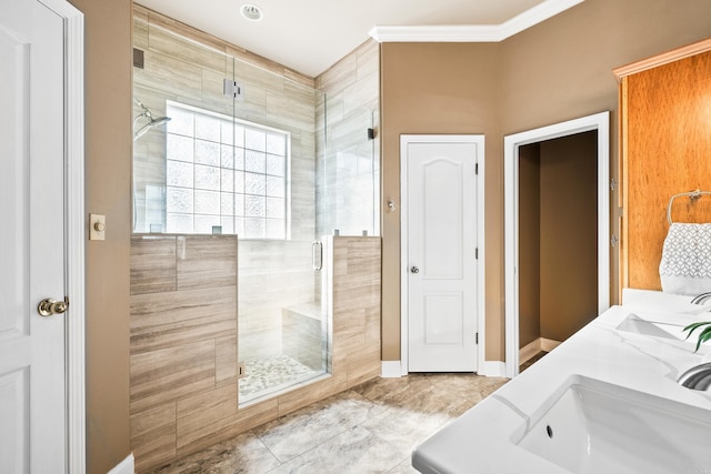 bathroom featuring ornamental molding, vanity, and a shower with shower door