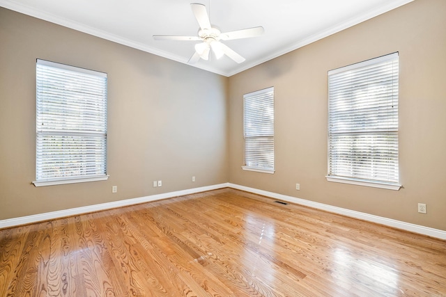 spare room with light wood-type flooring, crown molding, ceiling fan, and a healthy amount of sunlight