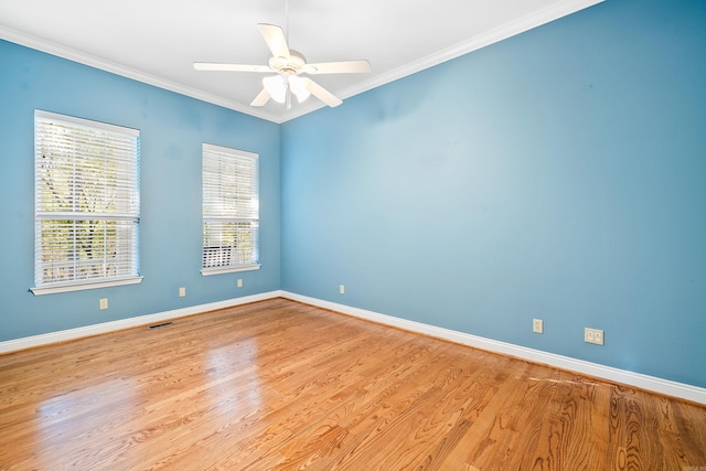 spare room featuring a wealth of natural light, light hardwood / wood-style flooring, ceiling fan, and ornamental molding