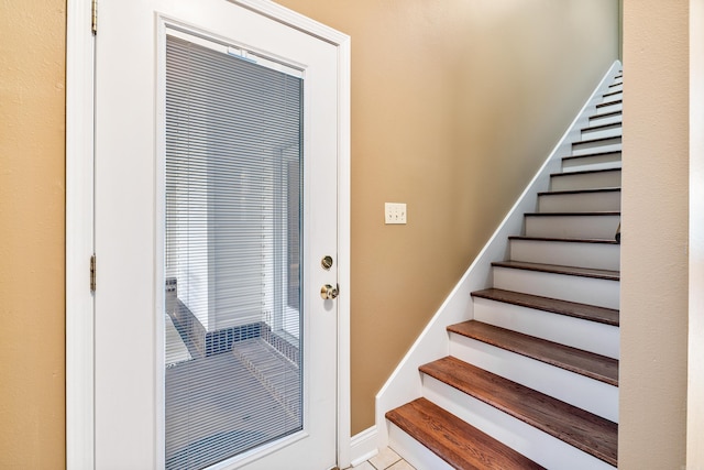 stairway with tile patterned floors