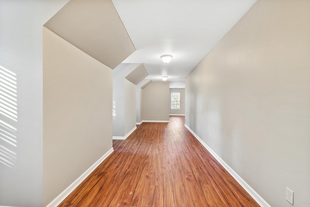 additional living space featuring wood-type flooring and lofted ceiling