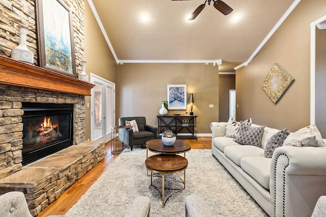 living room with ceiling fan, a fireplace, light hardwood / wood-style floors, and ornamental molding