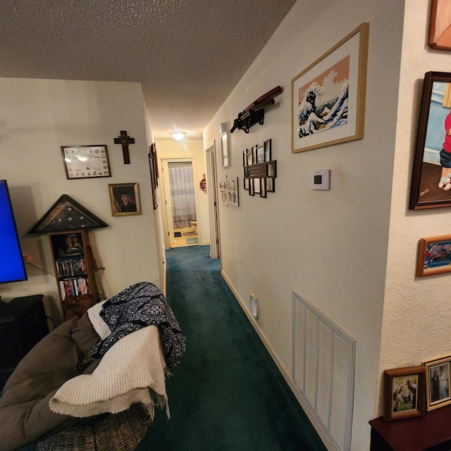 corridor with dark colored carpet and a textured ceiling