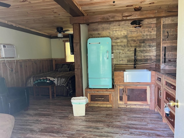 interior space with ceiling fan, sink, dark wood-type flooring, wooden ceiling, and wooden walls