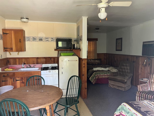 kitchen with sink, fridge, white gas stove, and ceiling fan