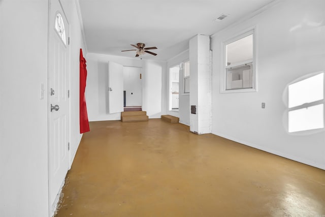 unfurnished living room featuring ceiling fan and concrete flooring