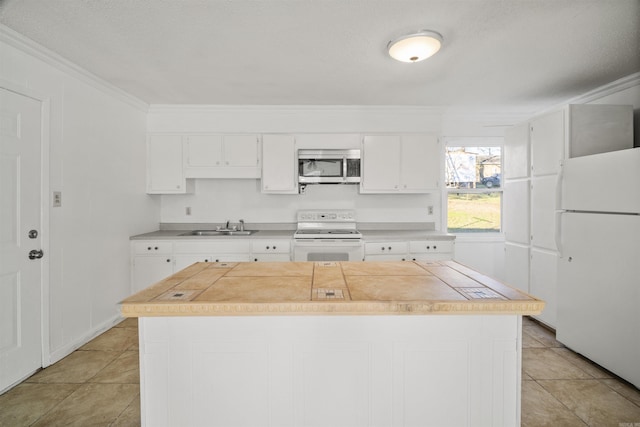 kitchen with white cabinets, white appliances, a kitchen island, and sink