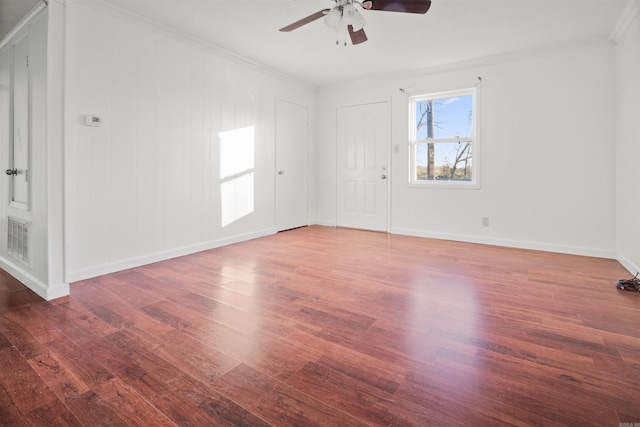 empty room featuring ceiling fan, dark hardwood / wood-style floors, and ornamental molding