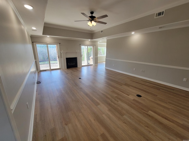 unfurnished living room with ceiling fan, wood-type flooring, and crown molding