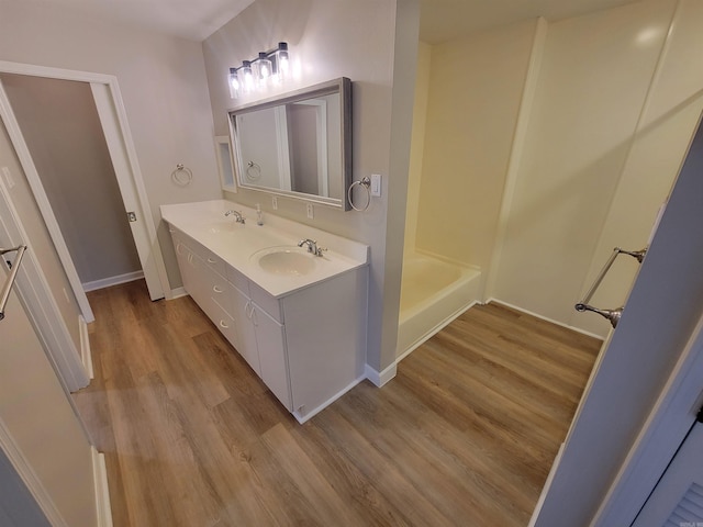 bathroom with hardwood / wood-style floors, vanity, and a bathtub