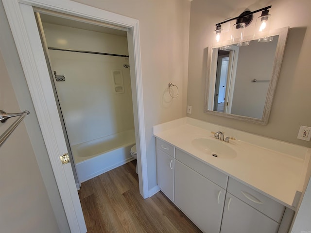 full bathroom featuring hardwood / wood-style floors, vanity, shower / bathtub combination, and toilet