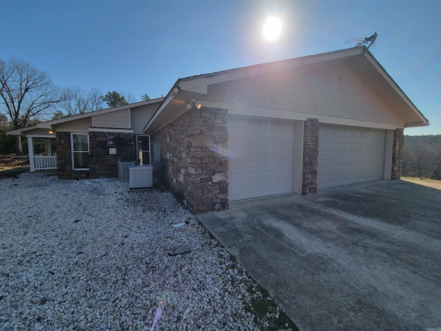 view of side of home with a garage and central AC