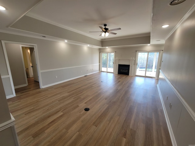 unfurnished living room with dark wood-type flooring, ceiling fan, and ornamental molding