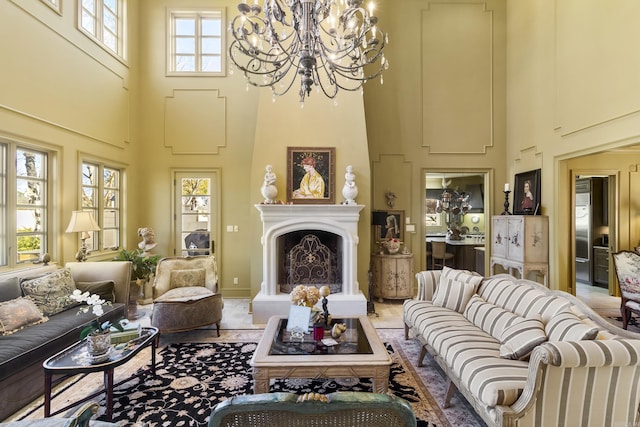 living room featuring a healthy amount of sunlight, a high ceiling, and an inviting chandelier