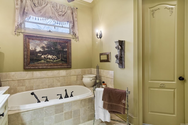 bathroom featuring tiled bath and vanity