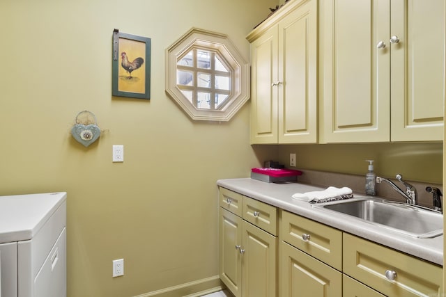 clothes washing area with cabinets and sink