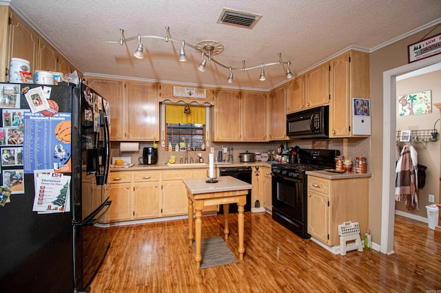 kitchen featuring a textured ceiling, crown molding, sink, black appliances, and light hardwood / wood-style floors