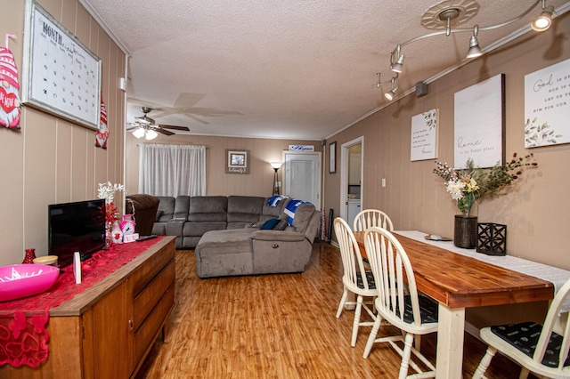 interior space featuring ceiling fan, light hardwood / wood-style flooring, crown molding, and a textured ceiling