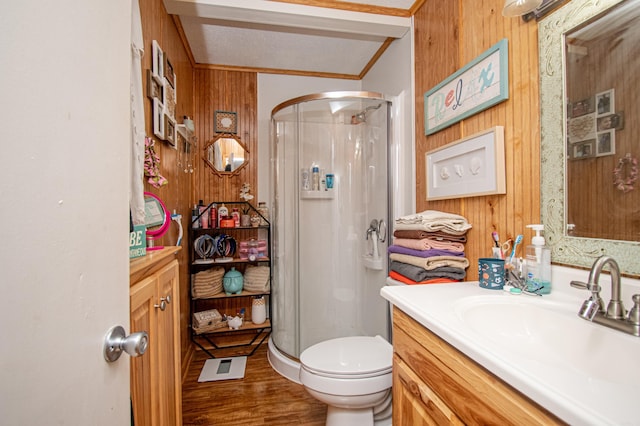 bathroom featuring vanity, a shower with door, and wood walls