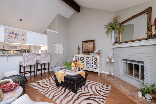 living room with vaulted ceiling with beams, dark hardwood / wood-style floors, and a fireplace