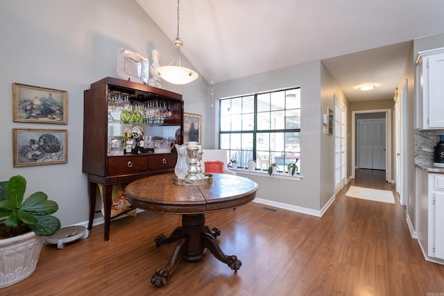 dining room with light wood-type flooring and lofted ceiling