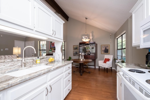 kitchen featuring white cabinetry, lofted ceiling, and sink