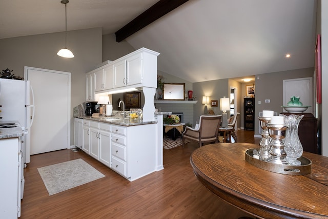 kitchen featuring hanging light fixtures, white cabinets, and dark stone counters