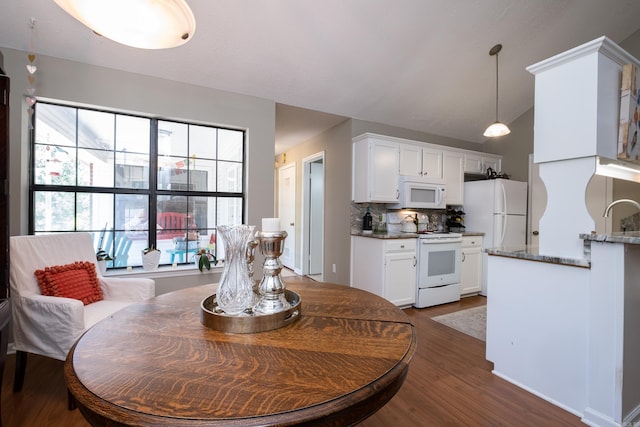 dining space featuring sink, dark wood-type flooring, and lofted ceiling