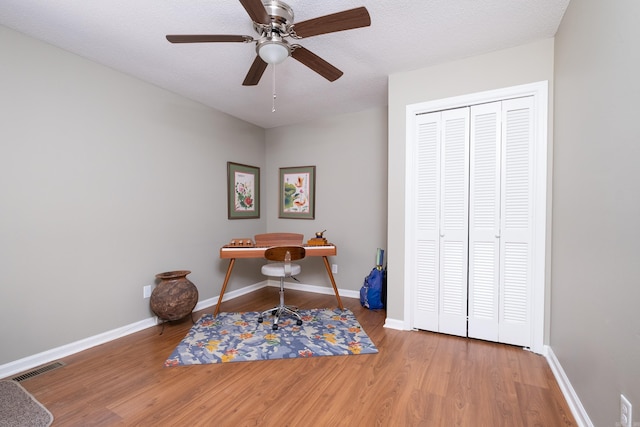 office with hardwood / wood-style flooring, ceiling fan, and a textured ceiling