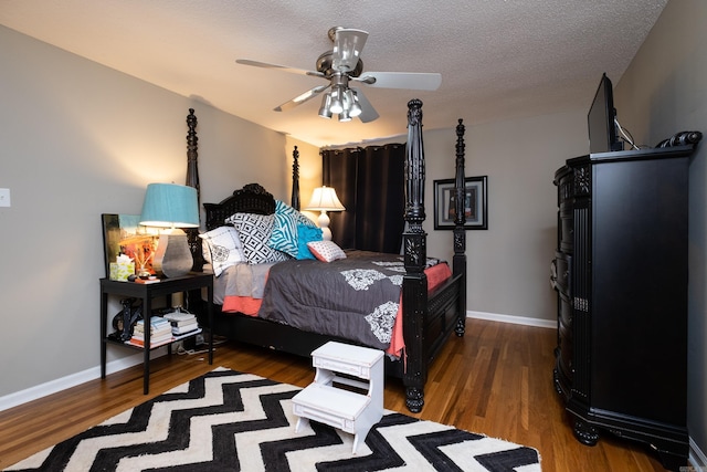 bedroom featuring ceiling fan, dark hardwood / wood-style floors, and a textured ceiling