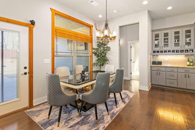 dining area featuring dark hardwood / wood-style floors and a chandelier