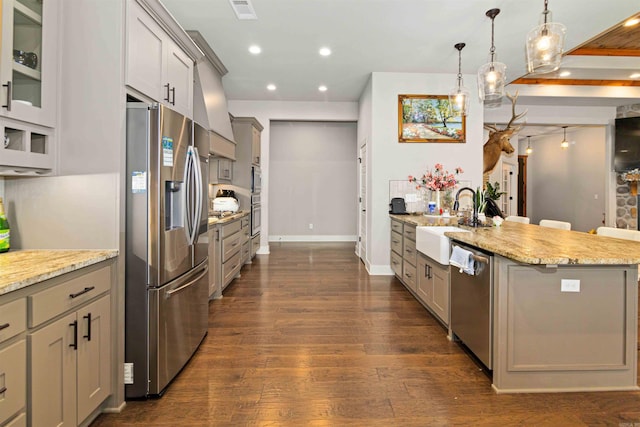 kitchen featuring appliances with stainless steel finishes, gray cabinetry, sink, pendant lighting, and dark hardwood / wood-style floors