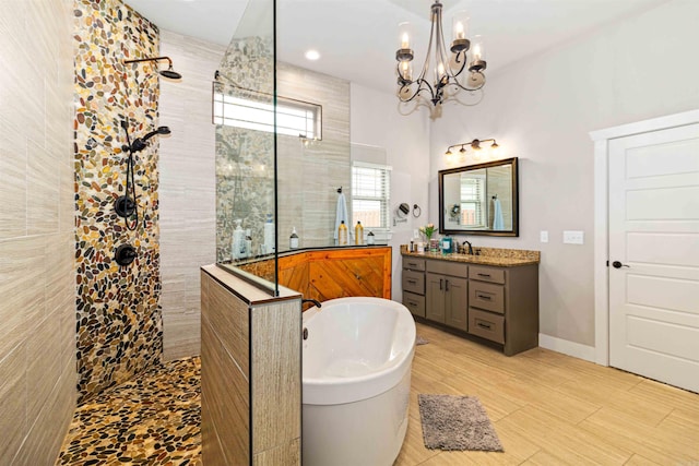 bathroom featuring vanity, independent shower and bath, and a notable chandelier