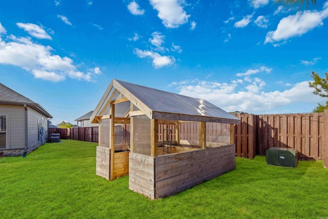 exterior space featuring a lawn, central AC unit, and an outdoor structure