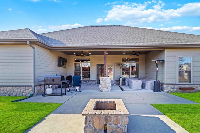 back of property with ceiling fan, a yard, a patio, and an outdoor fire pit