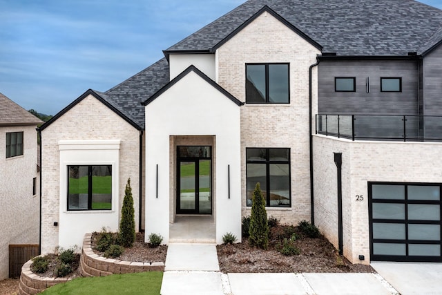 view of front of property featuring a balcony and a garage