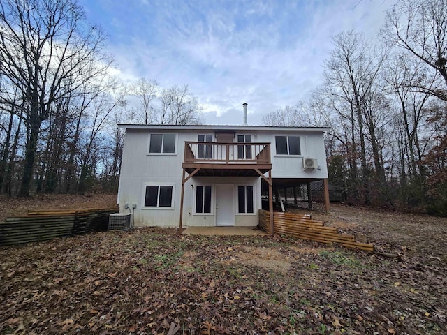 back of house featuring a deck, a patio area, central air condition unit, and a wall unit AC