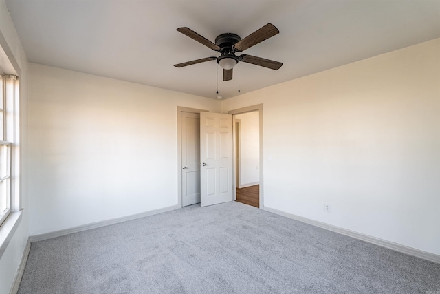 carpeted spare room featuring ceiling fan