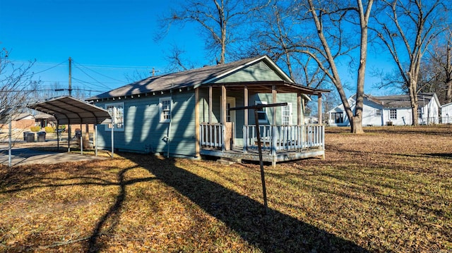 view of front of home featuring a carport, covered porch, and a front yard